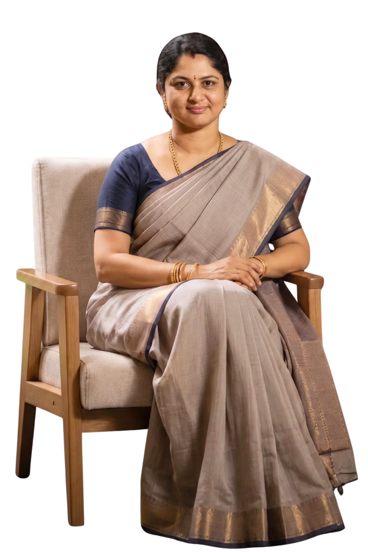 Mrs. Nanthini Ramakrishnan seated in a wooden armchair